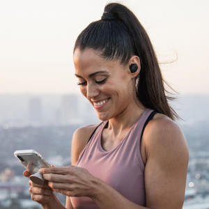 JLab Headphones: #1 True Wireless Headphones under $100 - photo of woman on her phone on adayinnmotherhood.com